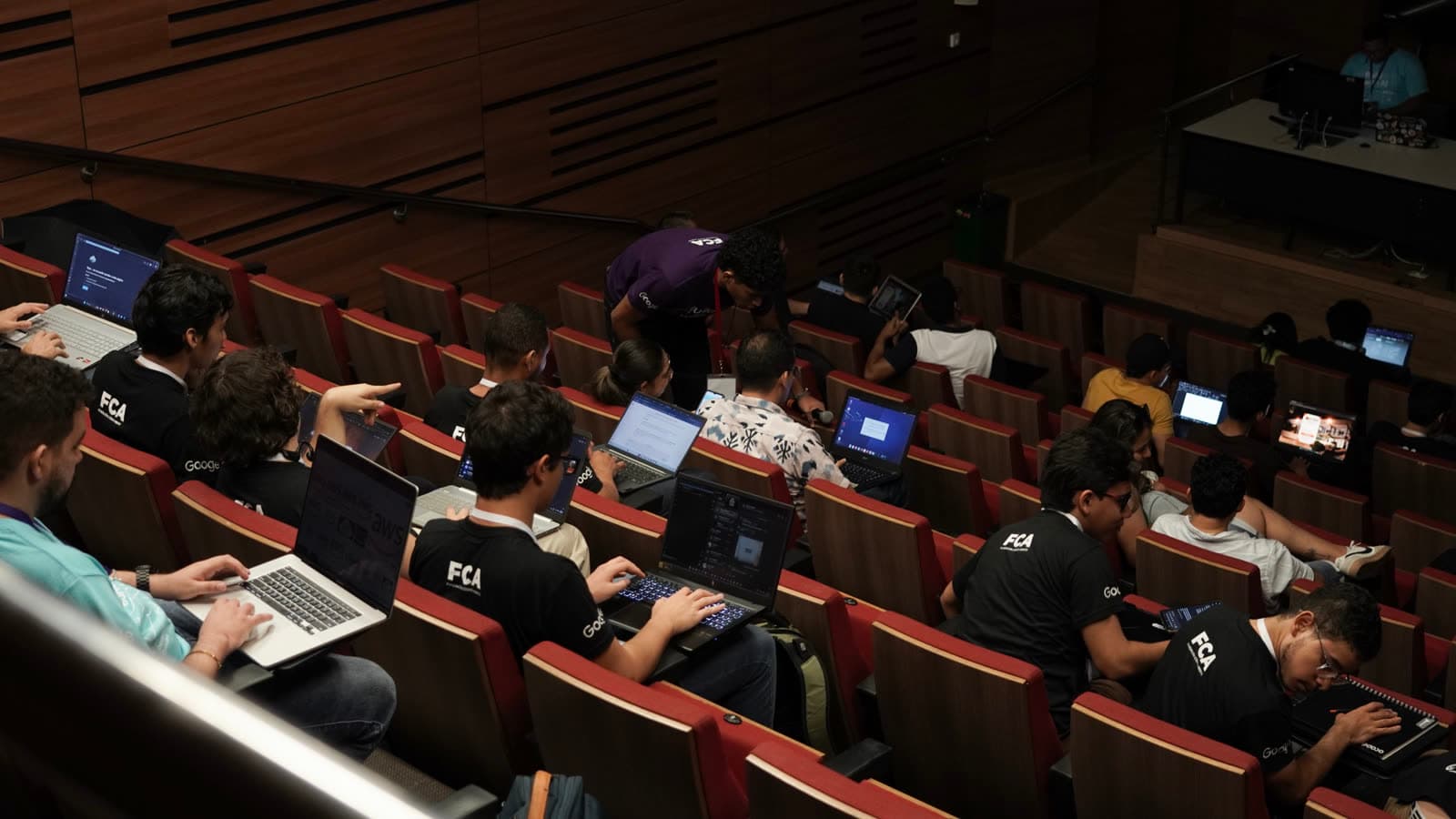 Vista aérea del auditorio con participantes trabajando en sus portátiles