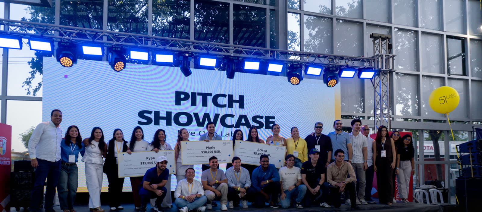 Emprendedores sobre el escenario del Pitch Showcase con cheques de premio